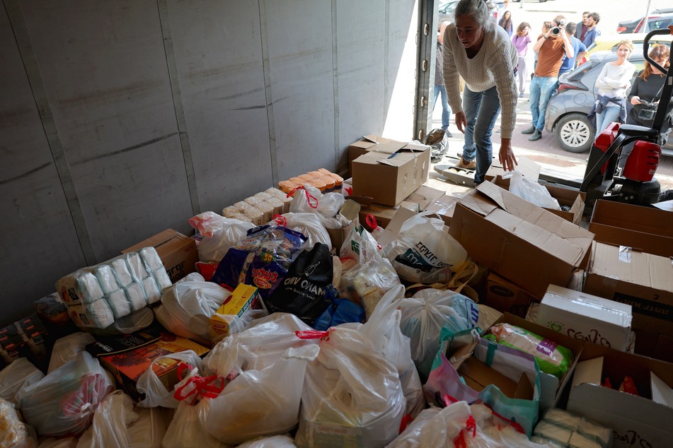 Activists from the Standing Together movement fill a truck with food aid at the parking lot of a shopping center of the southern Israeli city of Ashkelon before driving in a convoy toward the border with the Gaza Strip on March 7, 2024, in a show of support for Palestinians.