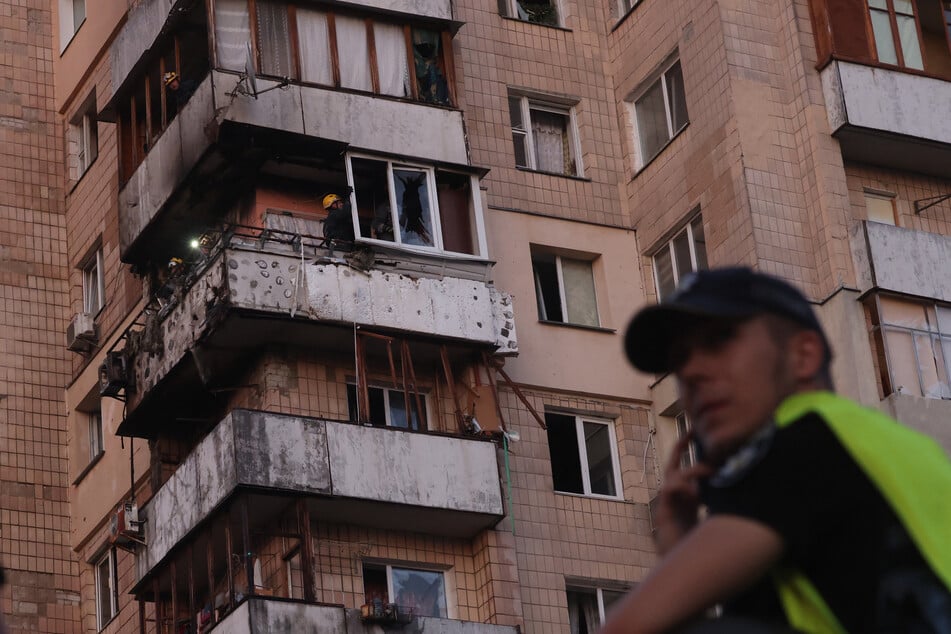 Einsatzkräfte arbeiten an einem beschädigten Wohnblock in Kiew. Das Haus wurde bei einem russischen Raketenangriff beschädigt.