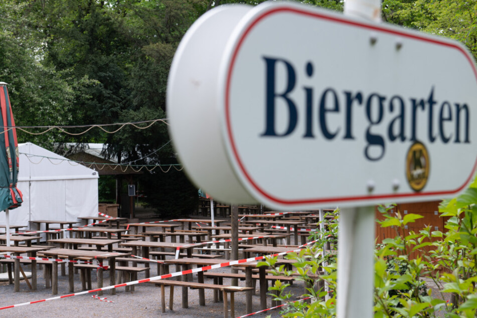 Ein Absperrband umgibt Bänke und Tische in einem geschlossenen Biergarten. Im Freistaat sollen Kneipen, Biergärten und Restaurants ab dem 15. Mai 2020 unter strengen Hygiene-Auflagen wieder öffnen dürfen.
