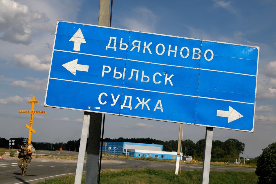 Ein schiefes Straßenschild mit den Richtungshinweisen der Orte Djakanowo (von oben nach unten), Rylsk und Sudscha steht am Stadtrand.