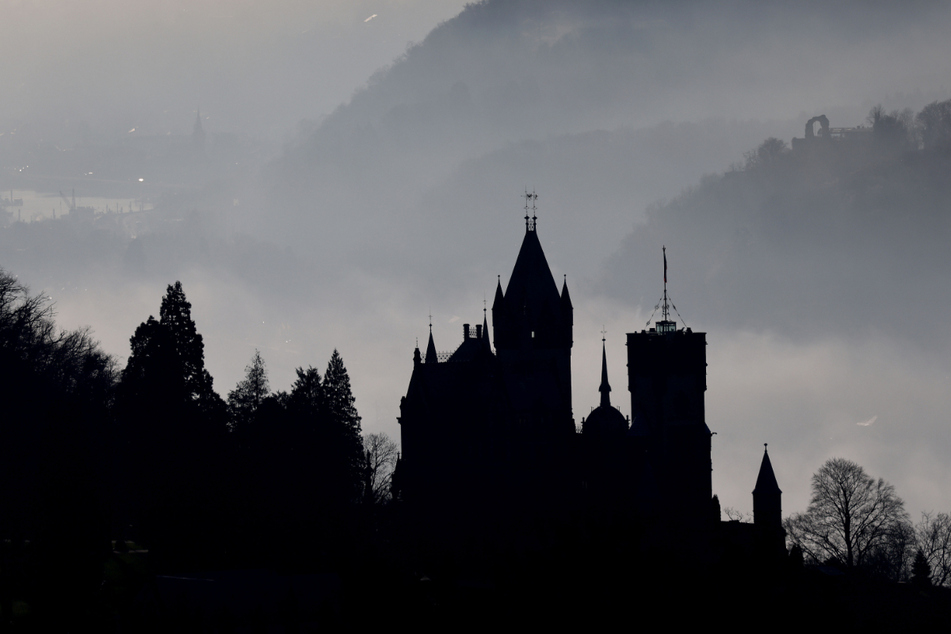 Bonn: Hinter Schloss Drachenburg ziehen Nebelschwaden durch das Rheintal.