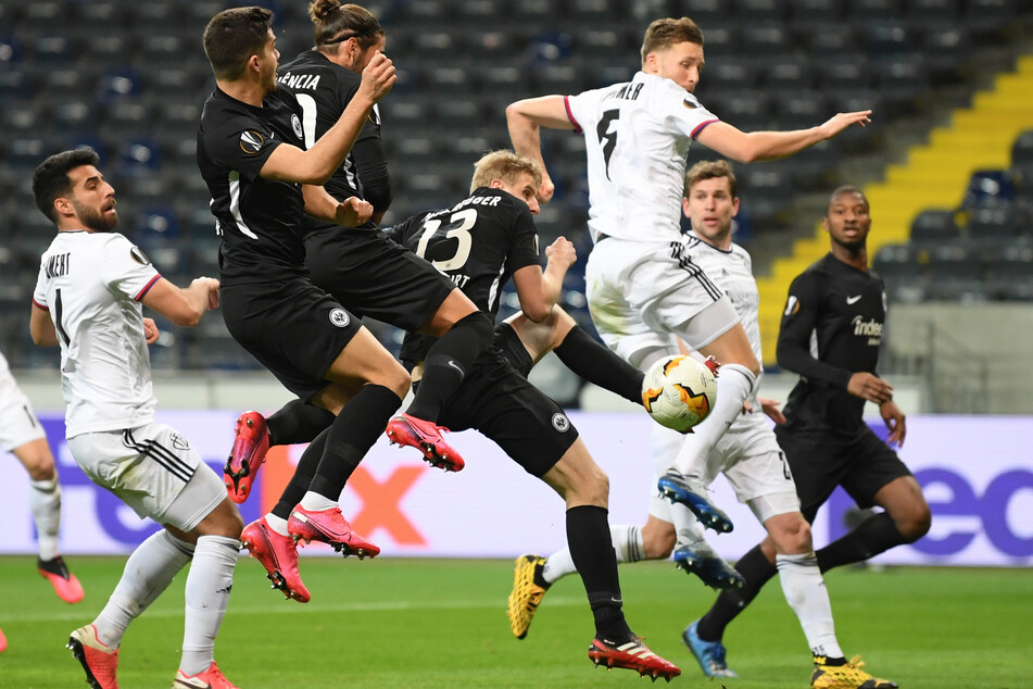 Frankfurts Martin Hinteregger (m., Rückennummer 13) und Basels Silvan Widmer kämpfen im Achtelfinal-Hinspiel der Europa League um den Ball.