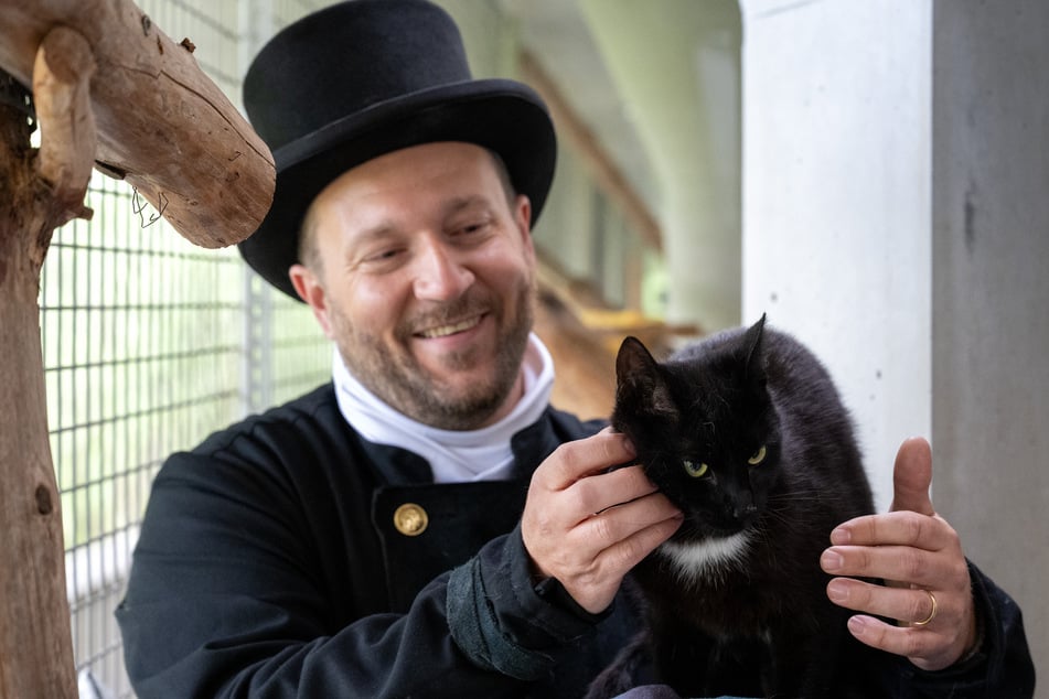 Nikolai Bach, Schornsteinfeger in Berlin-Tempelhof, streichelt während des Fotoshootings zur Charity-Aktion "Schwarz bringt Glück" im Tierheim des Berliner Tierschutzvereins einen schwarzen Kater.
