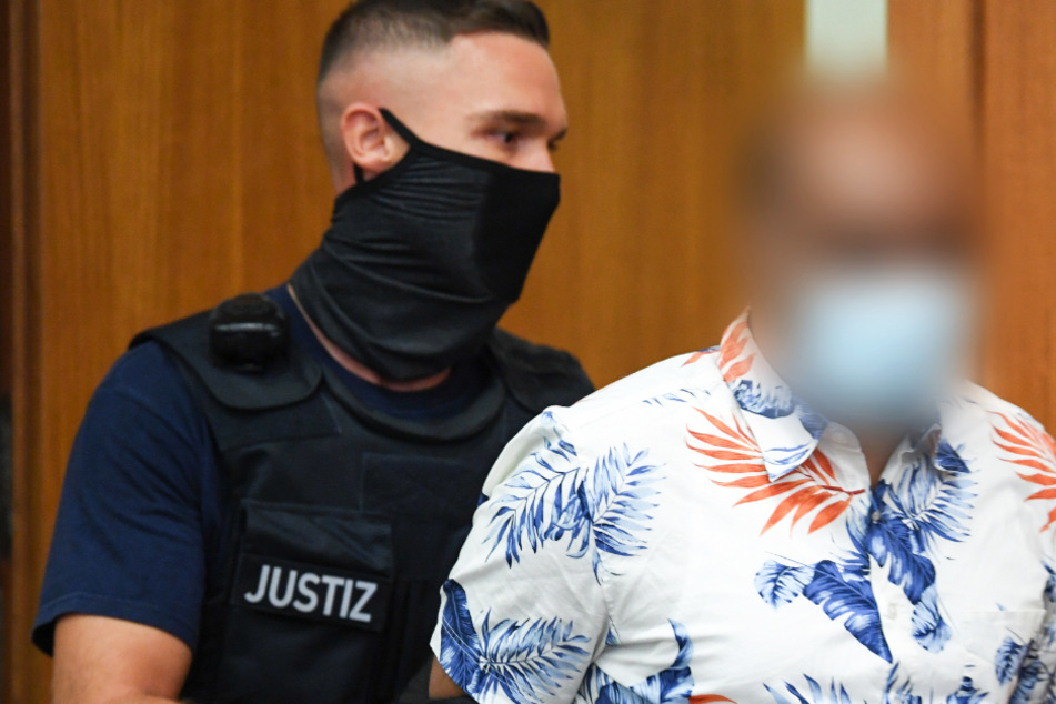 Das Foto vom 19. August zeigt den 41-jährigen Angeklagten (r.) und einen Justizbeamten.