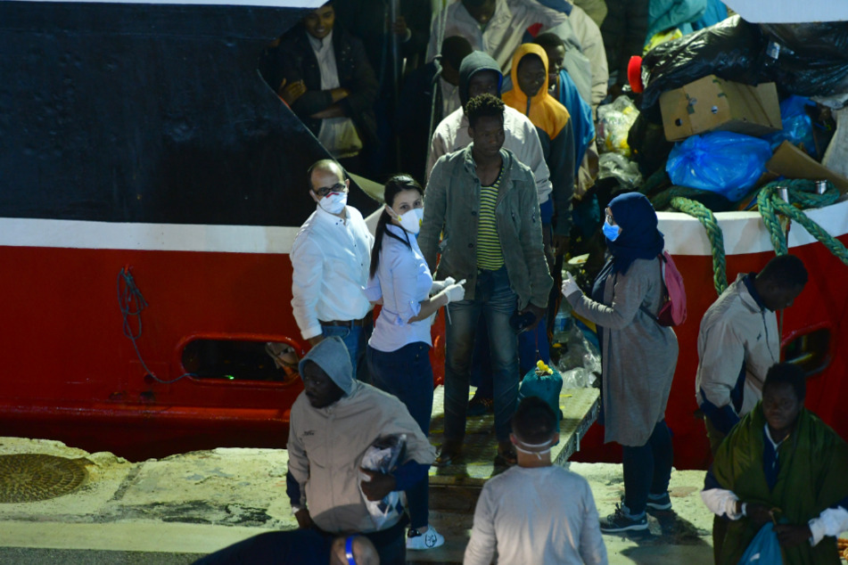 Migranten gehen im Hafen von Valletta von Bord.