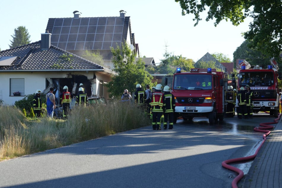 Einsatzkräfte begutachten das riesige Loch im Wohnzimmer.
