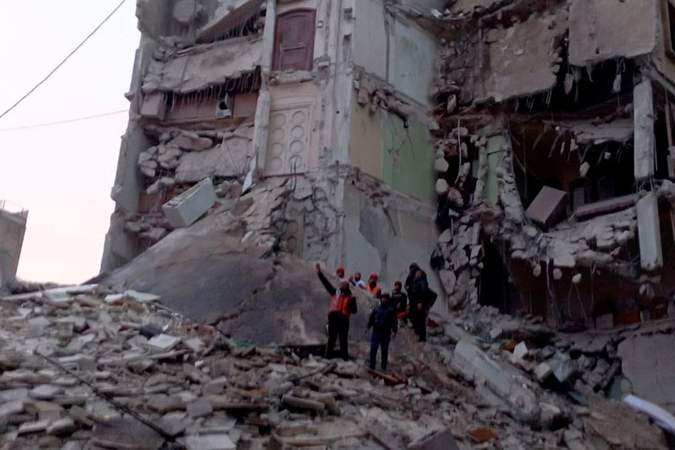 Rescuers work to recover bodies and survivors in Aleppo, Syria.