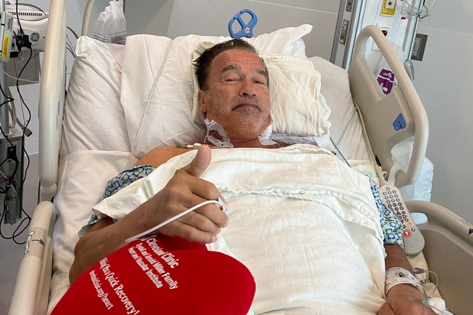 Arnold Schwarzenegger (73) giving the thumbs-up from his hospital bed after undergoing heart surgery.