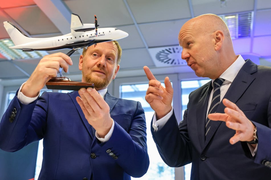 Sachsens Ministerpräsident Michael Kretschmer (51, CDU, l.) mit dem Modell einer D328 Eco. Eine Fertigungslinie für diese Flieger entsteht derzeit auf dem Flughafen Leipzig/Halle.