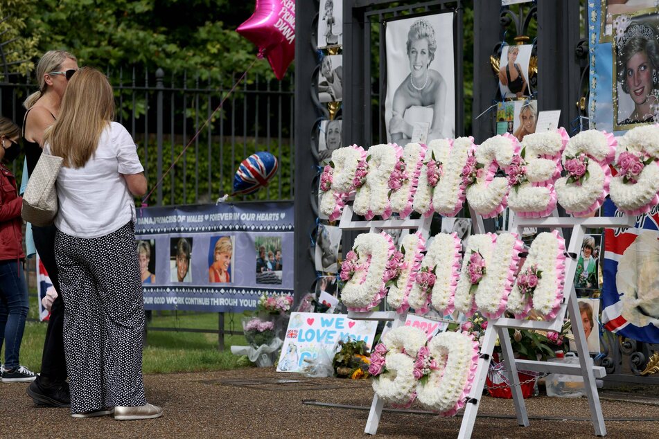 Well wishers place tributes to Diana Princess of Wales at Kensington Palace in London on what would have been her 60th birthday.