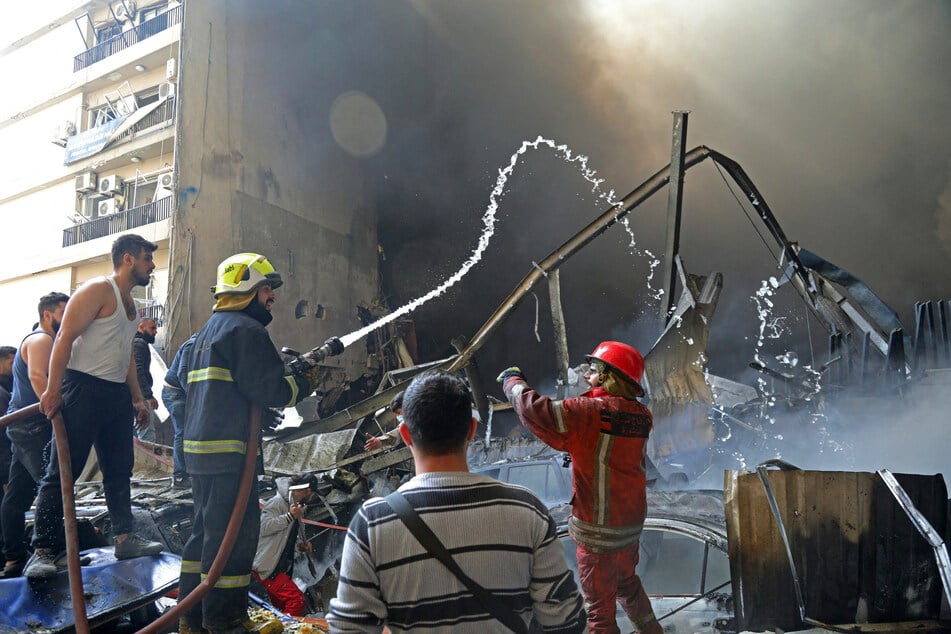 First responders and residents gather amid the rubble at the site of an Israeli airstrike in Beirut's Corniche al-Mazraa neighborhood on April 8, 2026.