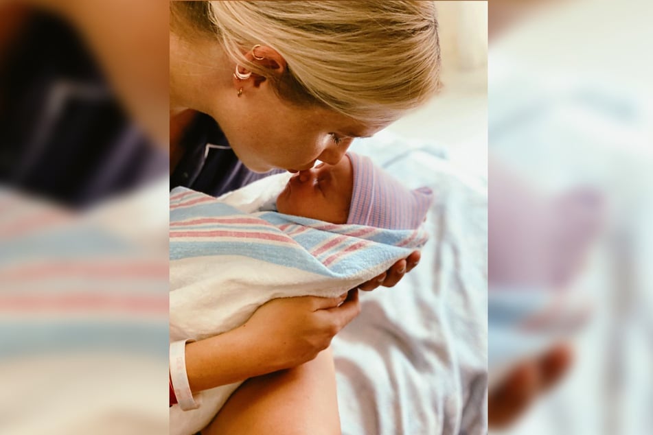 Claire Holt is holding daughter Elle.