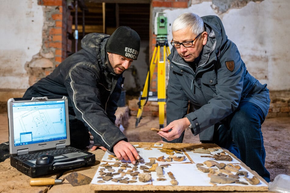 Grabungstechniker Stefan Johl (l.) und Christiane Hemker vom Landesamt für Archäologie auf historischer Spurensuche im Kutschenmuseum von Schloss Augustusburg.