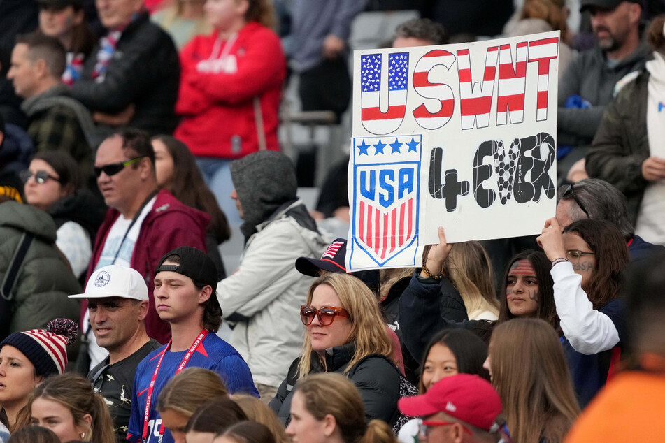 USA fans hold a sign reading "USWNT 4ever" after a group stage match against Vietnam in the 2023 FIFA Women's World Cup.