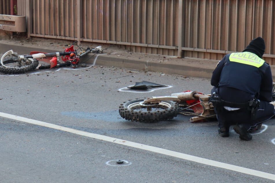 Ein Polizist hockt vor den Trümmern der in zwei Teile zerrissenen Maschine.