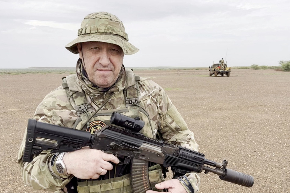 Yevgeny Prigozhin, chief of Russian private mercenary group Wagner, gives an address in camouflage and with a weapon in his hands in a desert area at an unknown location, in this still image taken from video possibly shot in Africa and published August 21, 2023.