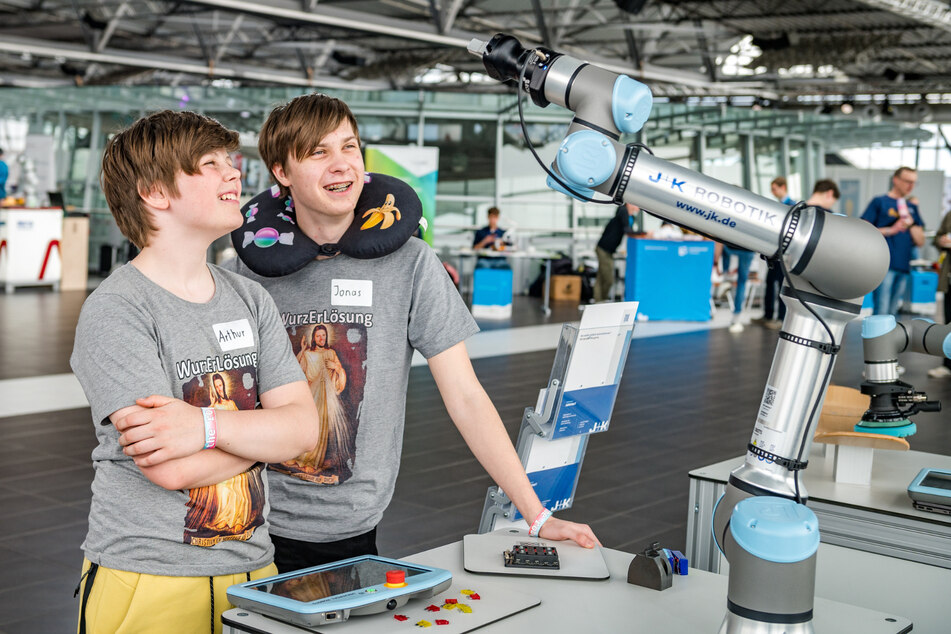 Arthur (12) und Jonas (16) aus Österreich amüsieren sich mit dem Roboterarm der Firma J+K Robotik, Universal Robots.