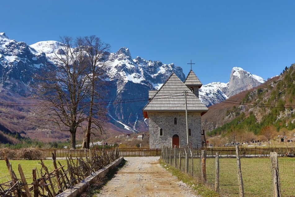 Die Kirche von Theth mit den albanischen Alpen im Hintergrund.