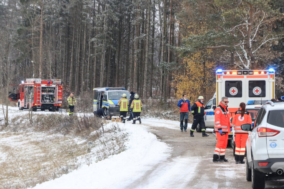 Einsatzkräfte stehen vor dem Wald in Strullendorf.