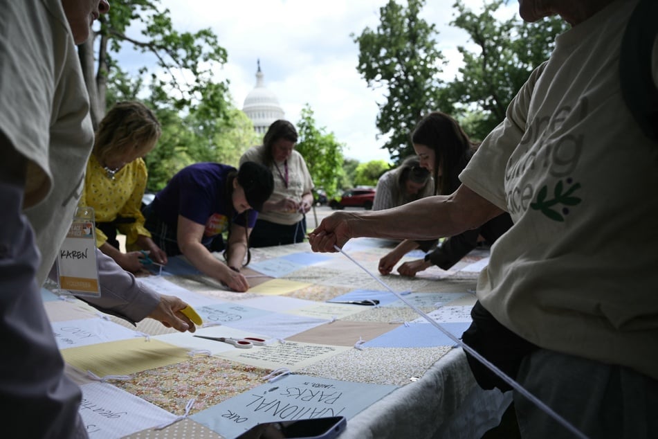 Members of Mormon Women for Ethical Government sew a quilt near the US Capitol for a "Quilting for the Constitution: Peace by Piece" event on May 6, 2025.