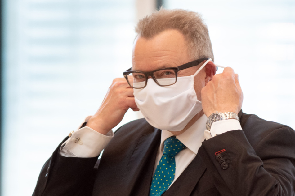Michael Stübgen (CDU), Minister des Innern und für Kommunales, legt nach der Sondersitzung des Landtages seinen Mundschutz an.