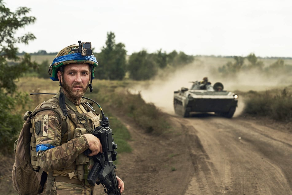 Ein Soldat der 3. Separatistenbrigade der Ukraine blickt auf einen Schützenpanzer.
