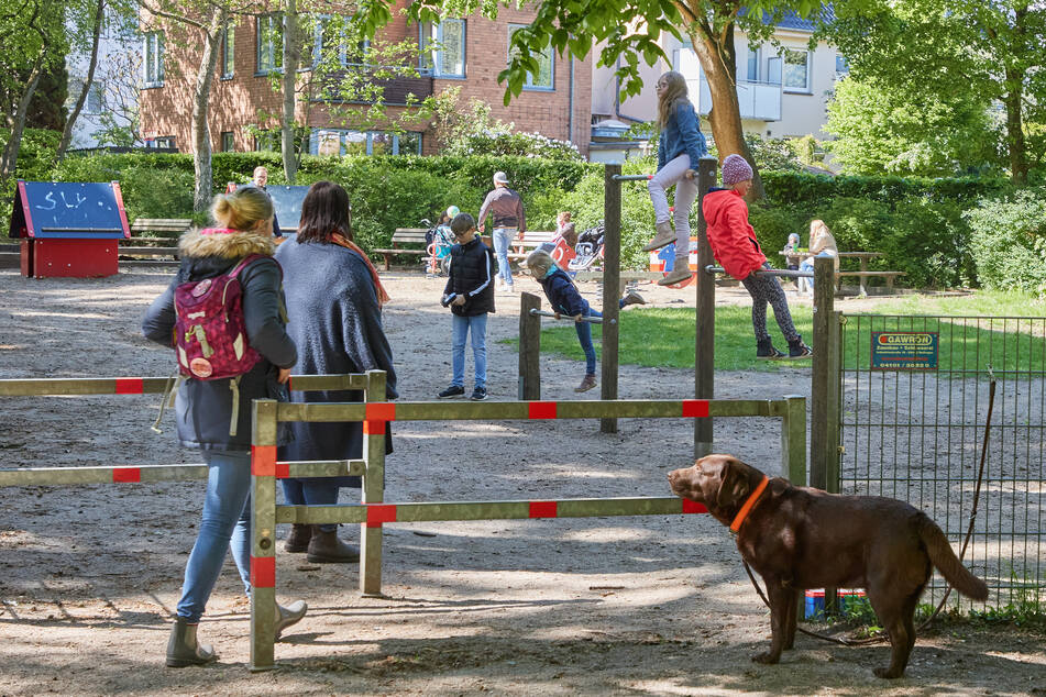 Kinder und Erwachsene besuchen einen Spielplatz in Hamburg-Lokstedt.