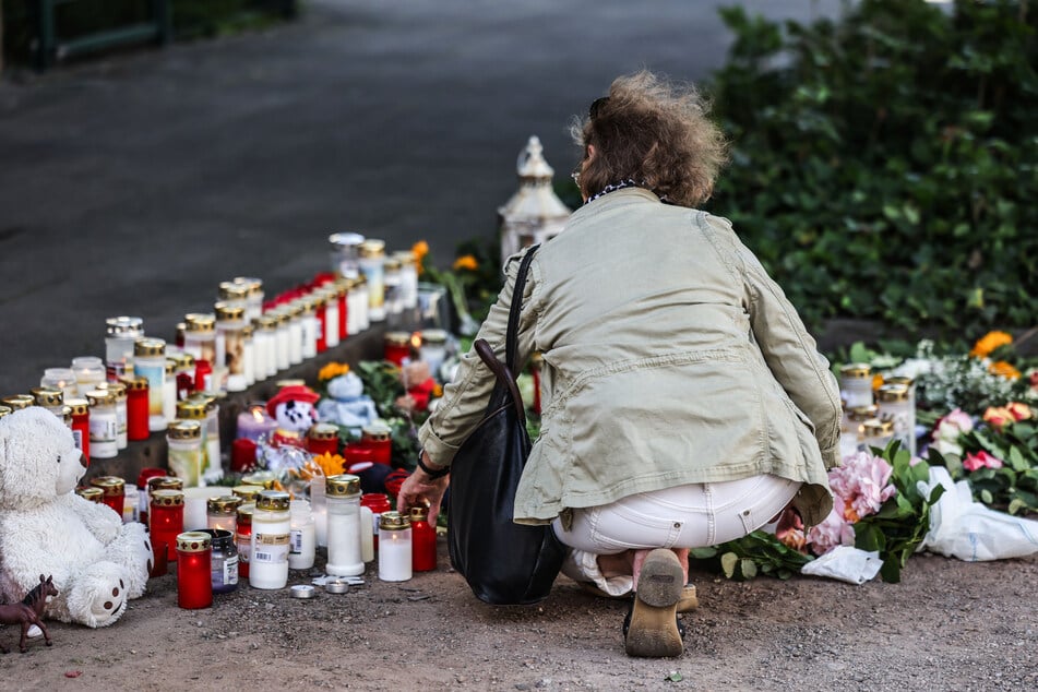 Ein Frau legt am Unfallort eine Kerze nieder. In Gedenken an die Verstobenen Jungs wird es am Freitag (29. Mai) eine stadtweite Schweigeminute geben.