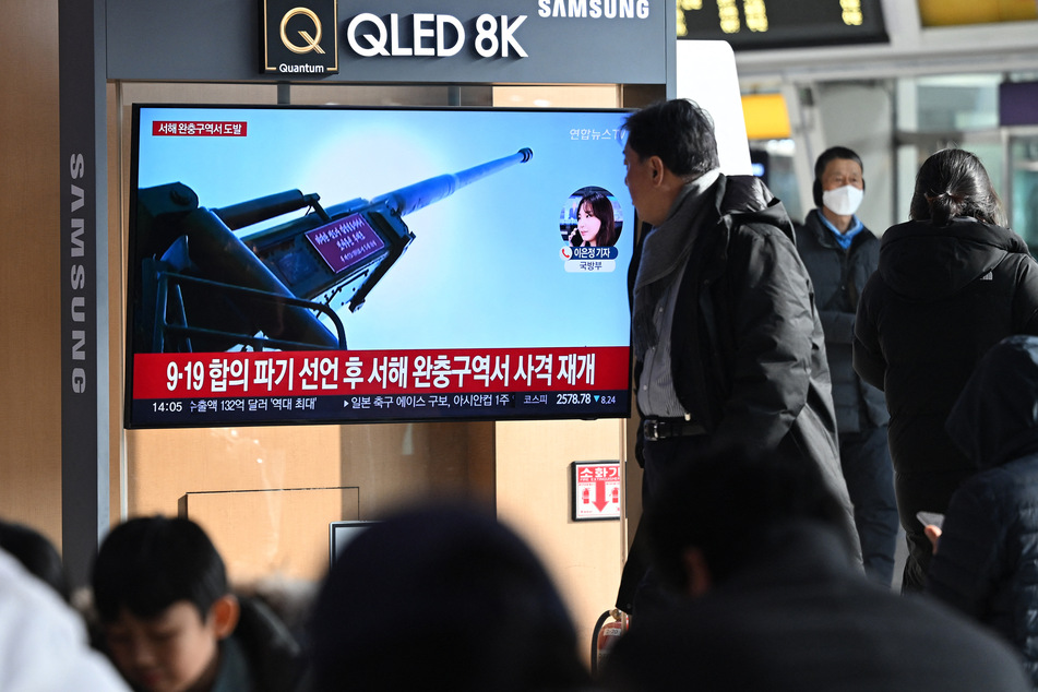 South Koreans watch a news broadcast showing footage of North Korean artillery fire on Friday.