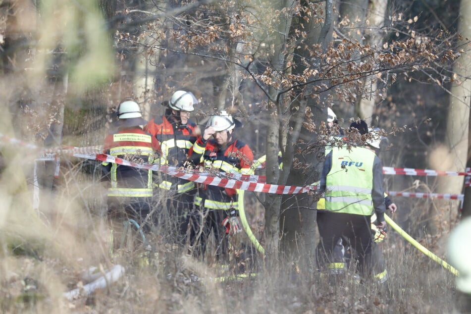 Ein Mitarbeiter der Bundesstelle für Flugunfalluntersuchung (BFU) begutachtet mit weiteren Einsatzkräften die Unglücksstelle im Wald.