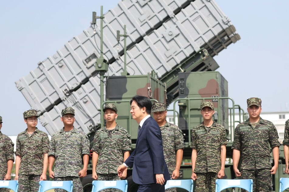 Taiwanese President Lai Ching-te walks past soldiers at a naval base following Chinese military drills earlier in the week in Taoyuan on October 18, 2024.