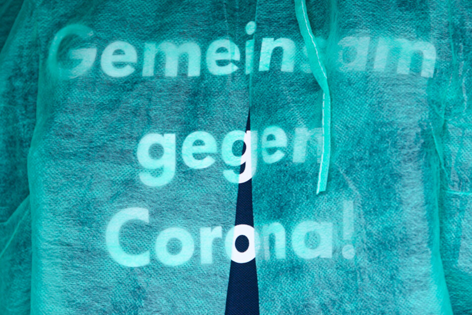 "Gemeinsam gegen Corona!", steht auf dem T-Shirt eines Impfarztes.
