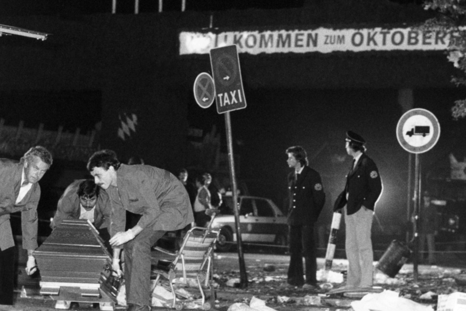 Ein Sarg wird am 26.9.1980 vom verwüsteten Tatort beim Oktoberfest in München weggetragen. (Archivbild)