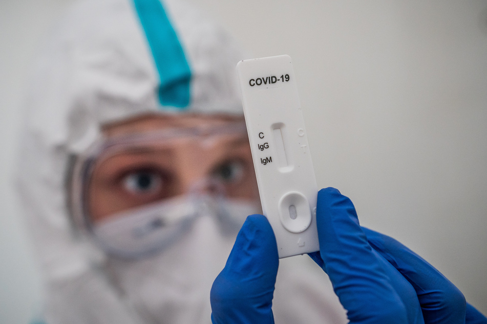 Ein Mitglied des medizinischen Personals prüft einen IgG-/IgM-Schnelltest zum COVID-19-Antikörper-Nachweis.
