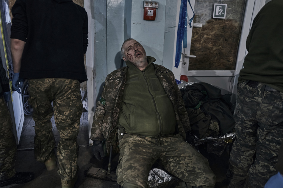 Ein verwundeter ukrainischer Soldat sitzt an einem medizinischen Stabilisierungspunkt in der Nähe von Bachmut. Die ukrainischen Verteidiger von Bachmut im Osten der Ukraine wehren sich nach britischer Einschätzung weiter erbittert gegen eine Einkesselung durch russische Truppen.