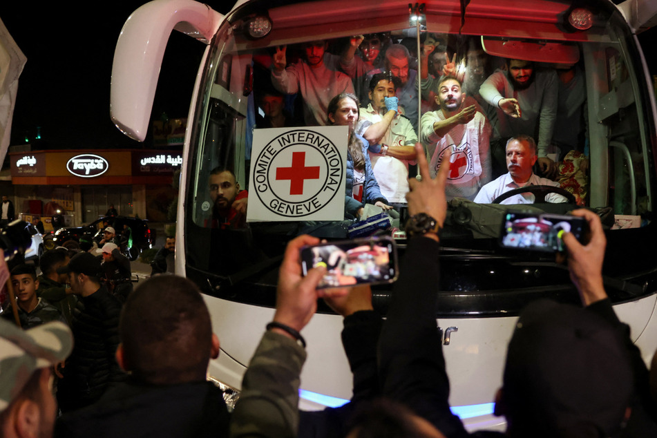 A bus transporting Red Cross staff and Palestinian prisoners released from Israeli jails in exchange for hostages released by Hamas from the Gaza Strip drives through Ramallah in the occupied West Bank early on November 26, 2023.