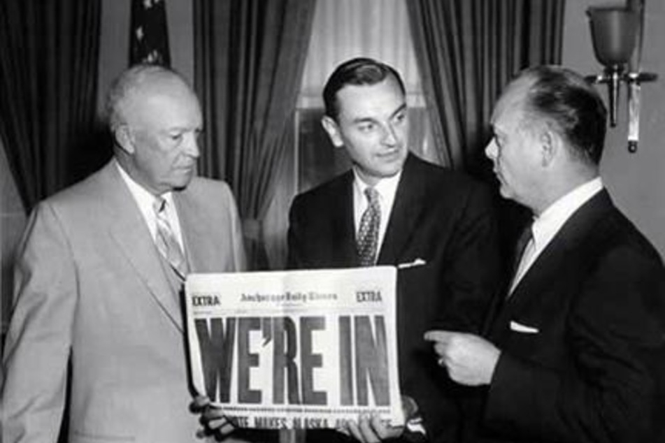 US President Dwight D. Eisenhower (l.) speaks with Territorial Governor of Alaska Mike Stepovich (c.) and Secretary of the Interior Fred A. Seaton during the signing of the Alaska Statehood Bill on July 7, 1958.