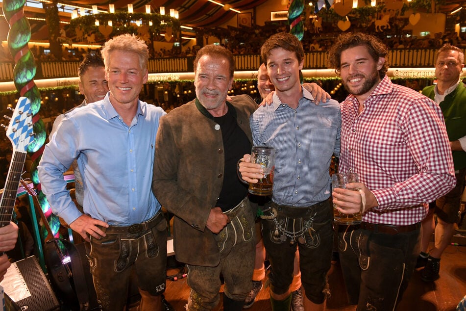 Patrick Schwarzenegger (2.v.r.) neben seinem Vater Arnold Schwarzenegger (78, 2.v.l.) im Jahr 2022 auf dem Oktoberfest. (Archivbild)