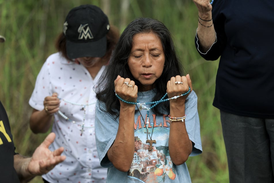 People pray near the entrance to Alligator Alcatraz on July 12, 2025, in Ochopee, Florida.