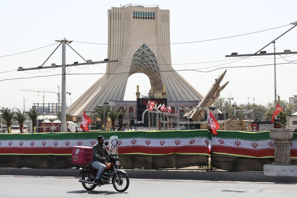 A man rides past Iranian-made Zolfaghar missiles displayed at Azadi Square in Tehran on July 24, 2026.