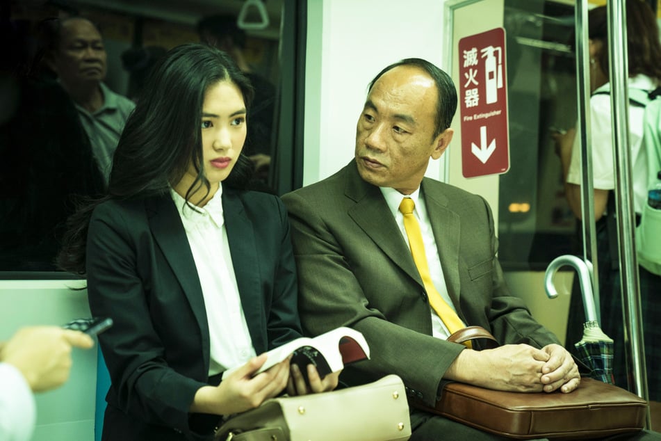 Ein älterer Geschäftsmann (Tzu-Chiang Wang, 54, r.) bedrängt die junge Kat (Regina Lei, 21, l.) in der U-Bahn. Sie weist ihn deutlich zurück und droht, die Polizei zu rufen.
