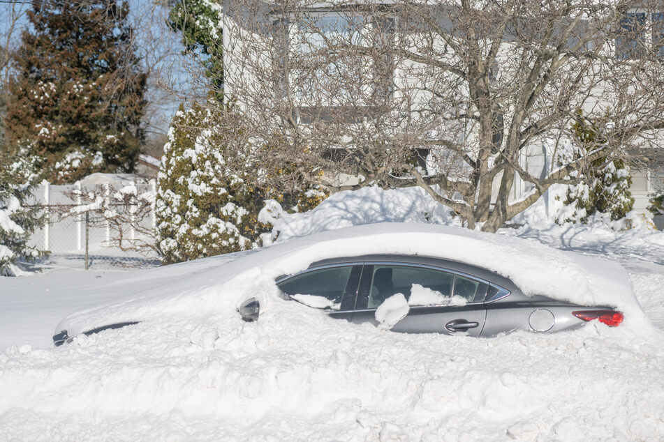 A car sits buried in snow after a blizzard hit the Northeast on January 30, 2022 in Centereach, New York.