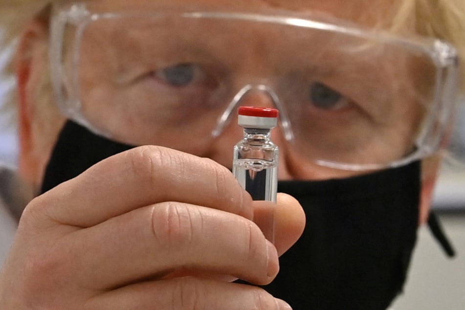Boris Johnson (56), Premierminister von Großbritannien, hält eine Ampulle des von Astrazeneca und der Universität Oxford entwickelten Corona-Impfstoffs in der Hand. Jetzt soll das Impfen noch schneller gehen.
