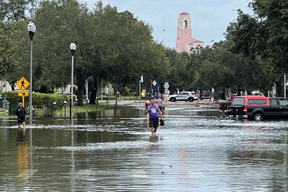 Those in St. Petersburg, Florida, wade through flood waters after Hurricane Idalia on Wednesday.
