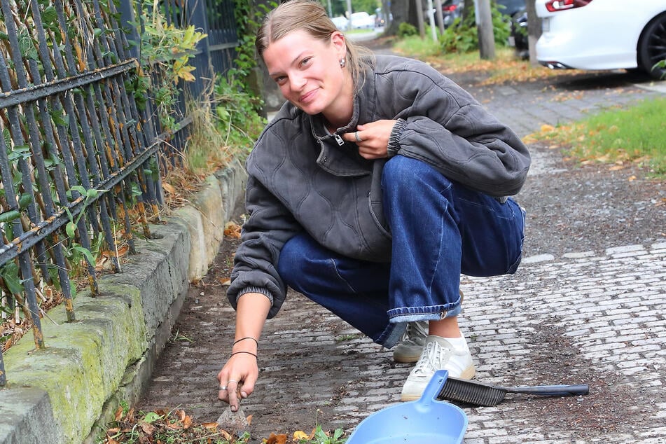 Anna Rednik (24) kann irgendwann nicht mehr auf der Decke stillsitzen, entfernt Unkraut und Moos am Rand des Gehwegs.