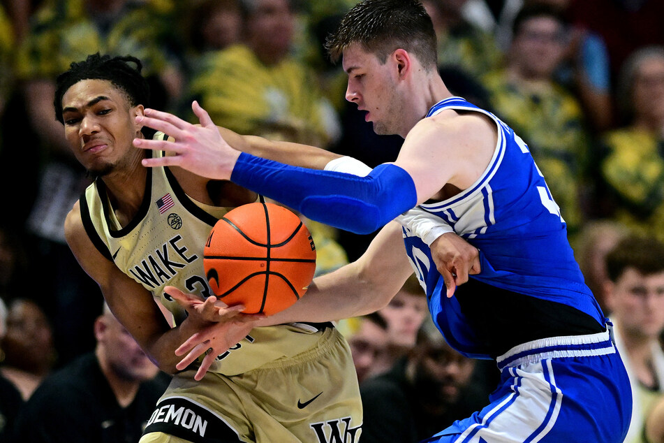 Duke University center Kyle Filipowski (r.) was hurt when Wake Forest fans came on to the court.