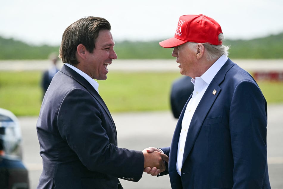 Florida Governor Ron Desantis (l.) shakes hands with President Donald Trump upon the latter's arrival at Dade-Collier Training and Transition Airport in Ochopee on July 1, 2025.