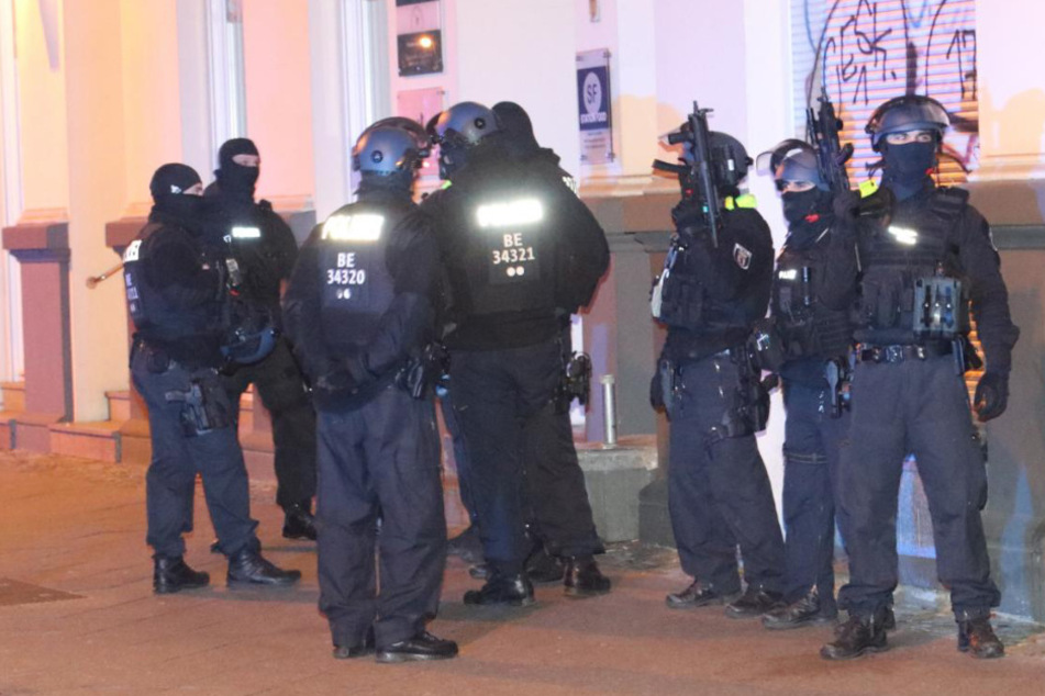 Schwer bewaffnete Polizisten sichern die Umgebung.