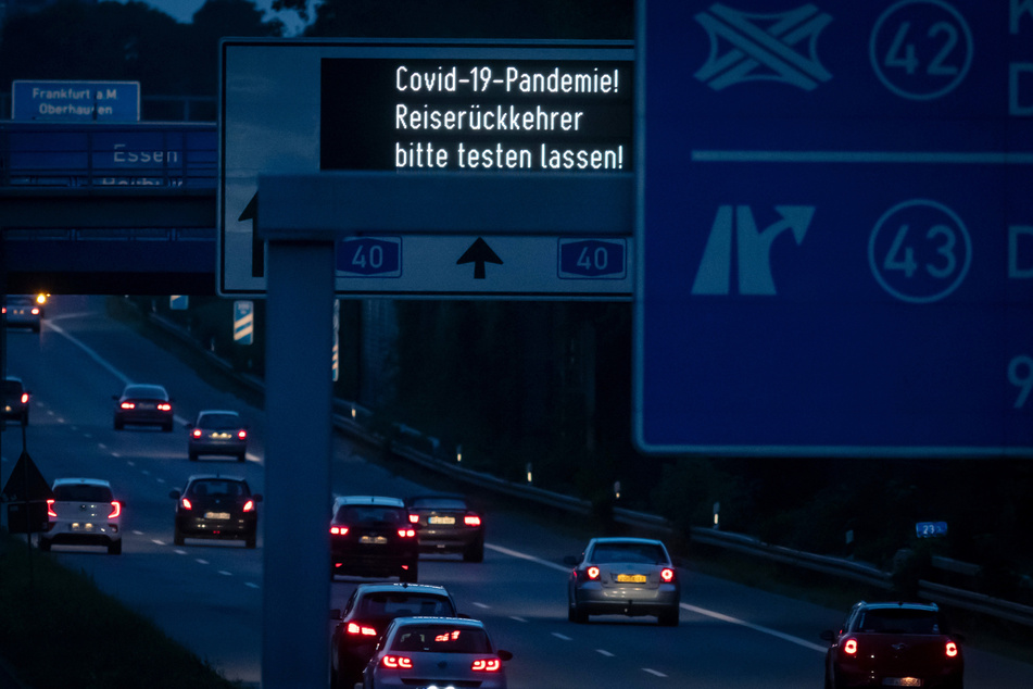 "Covid-19-Pandemie! Reiserückkehrer bitte testen lassen!" ist auf der Anzeigetafel über einer Autobahn zu lesen.