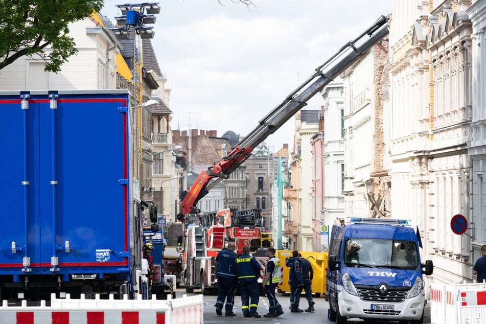 Ein Kran entfernt die Überreste an dem Schuttberg des eingestürzten Wohnhaus in der Innenstadt.